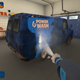 A screenshot of the game shows someone cleaning a dirty van in a garage.